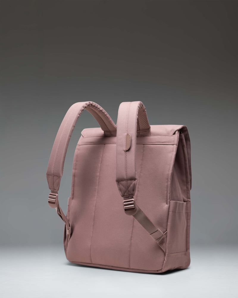 Herschel Supply Co. City Backpack in Ash Rose pink, showing the front view with a single magnetic strap closure and woven label logo.
