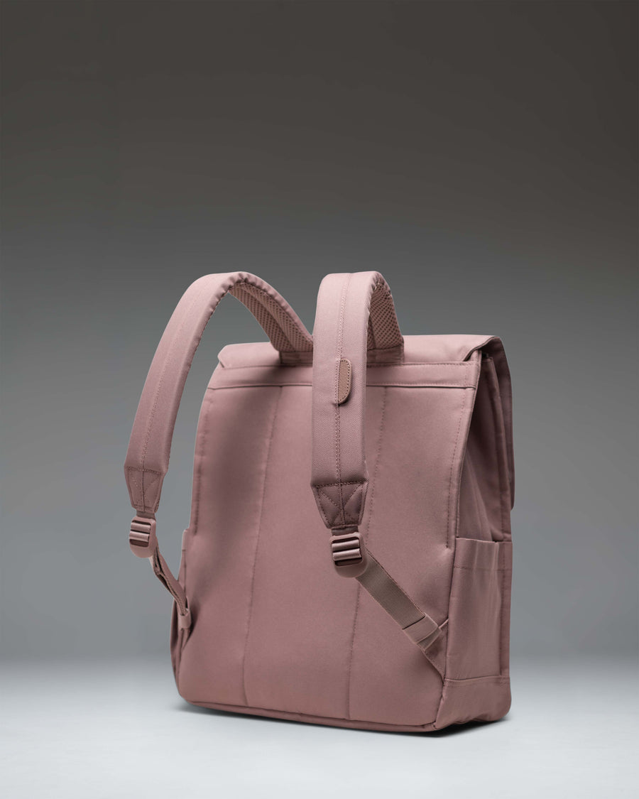 Herschel Supply Co. City Backpack in Ash Rose pink, showing the front view with a single magnetic strap closure and woven label logo.