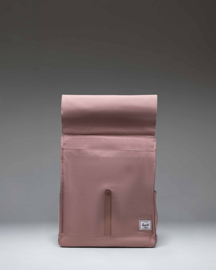 Herschel Supply Co. City Backpack in Ash Rose, showcasing a classic design with a single magnetic strap closure and a front storage sleeve.
