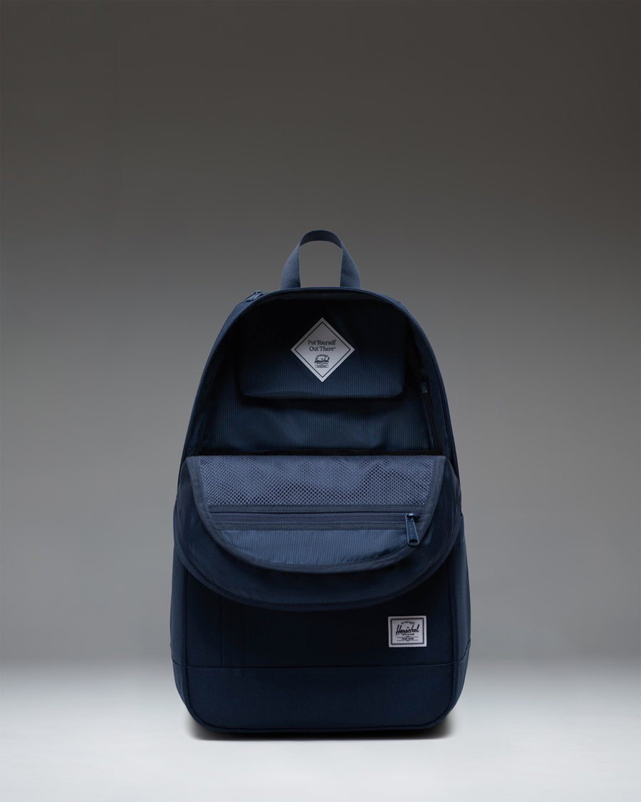 Navy Herschel Supply Co. Seymour Backpack in Navy blue, showcasing its streamlined design, zippered compartments, and signature diamond detail.