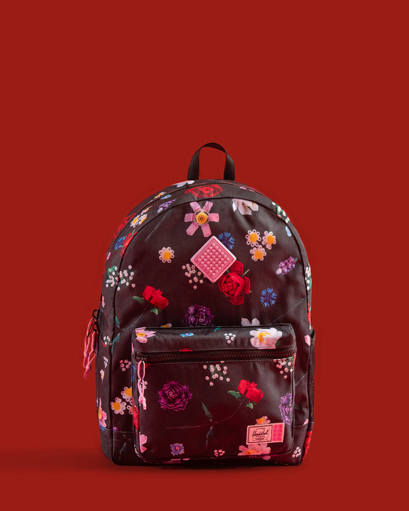 Herschel Supply Co. LEGO Heritage Youth Backpack in Falling Florals print, showing the front pocket with LEGO brick-inspired details.