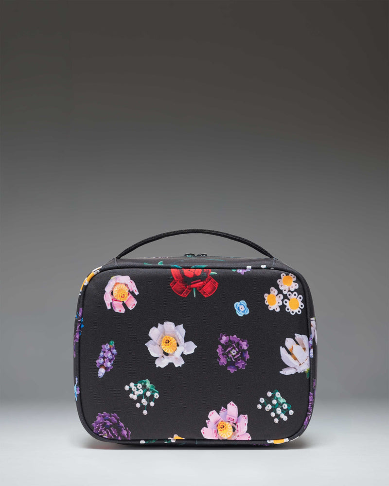 Herschel Supply Co. LEGO Pop Quiz Lunch Box in Falling Florals floral print, showing the insulated main compartment and front pocket.