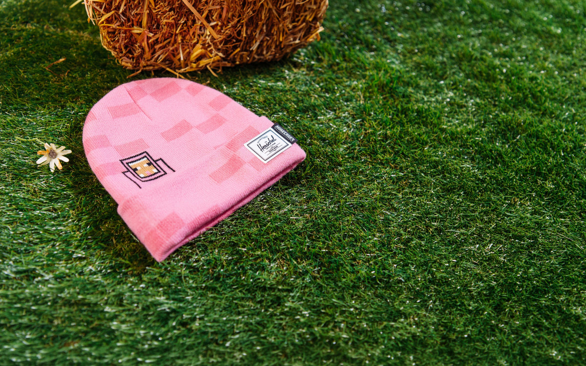 Herschel Supply Co. Minecraft Elmer Kids Beanie in Pink Sheep, styled on a model for a desktop banner view.